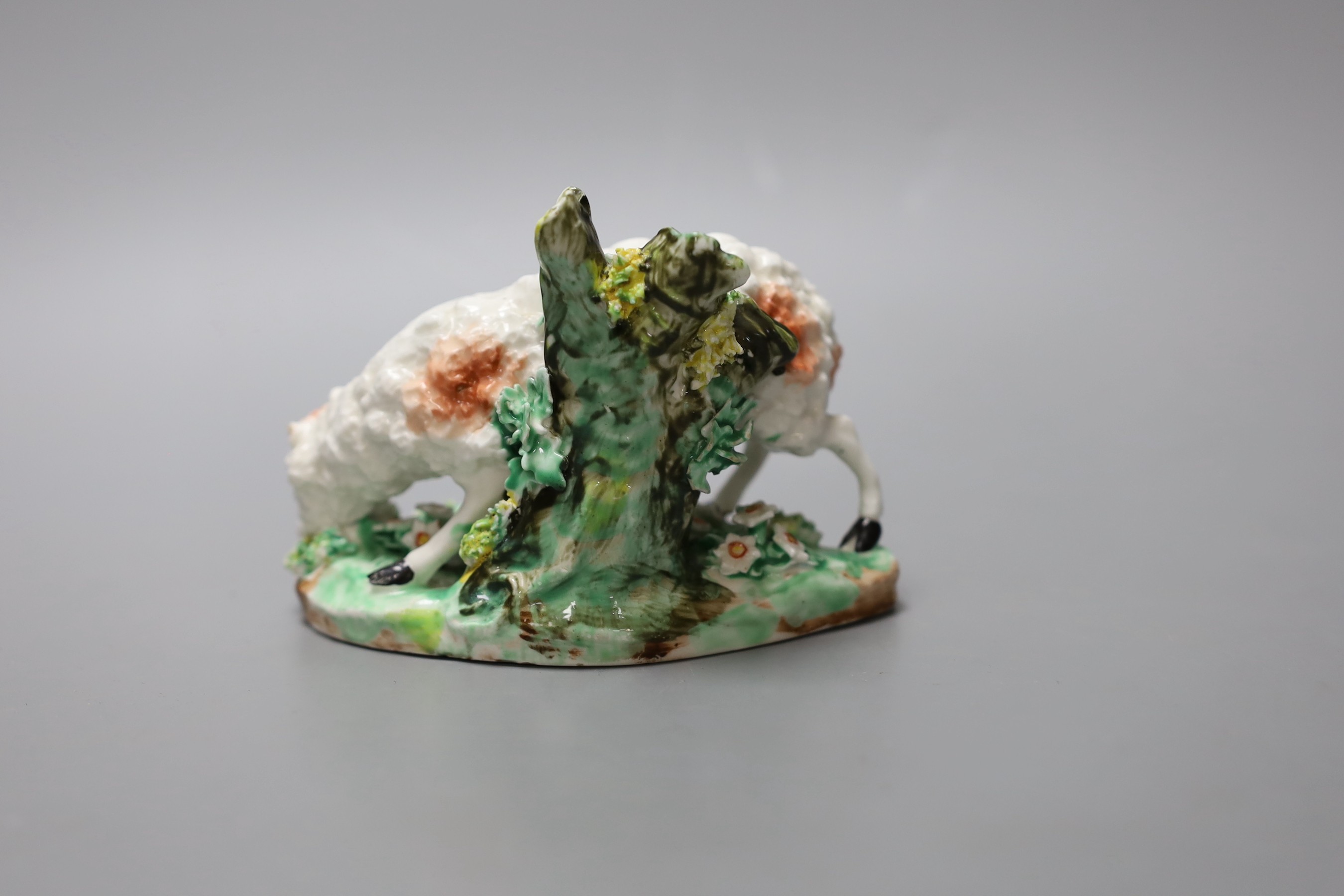 A rare Derby model of a sheep eating grass, c.1760-65, patch mark and incised mark for Isaac Farnsworth, 9cm tall